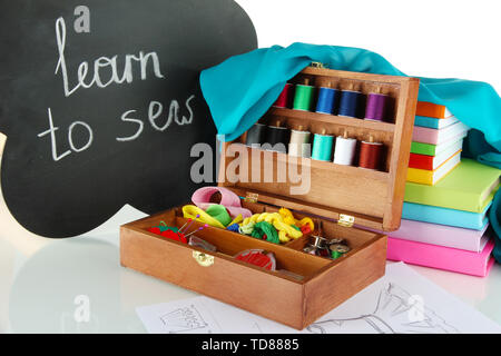 Sewing kit in wooden box and books isolated on white Stock Photo