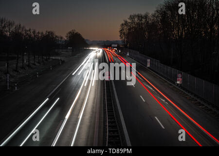 Highway leading in to the alps by sunset. You can see light trails from the cars and the last glowing from sunset in the alps. Stock Photo