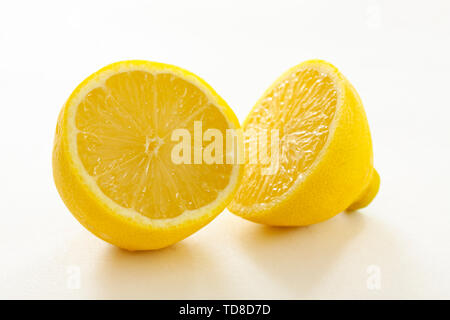 Two halves of a fresh organic lemon on white background - closeup Image Stock Photo