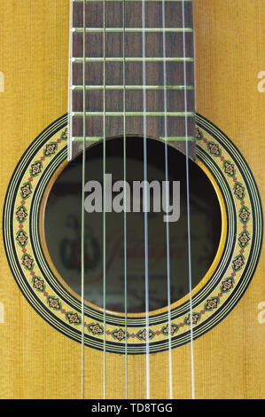 Close-up of a soundhole and rosette of a Spanish guitar with its six strings Stock Photo