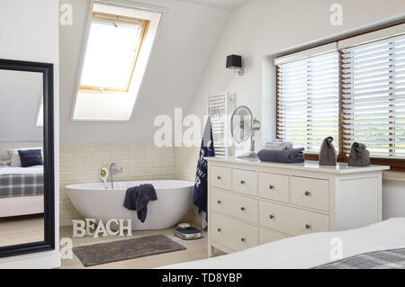 Freestanding bathtub and chest of drawers in open plan bedroom  UK & IRISH USE ONLY Stock Photo