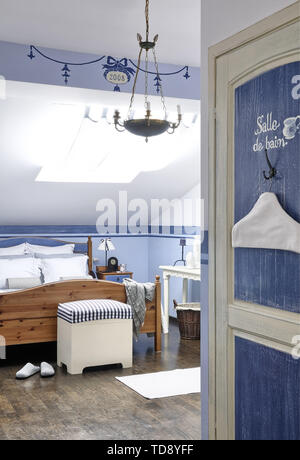 View into blue bedroom with pine wood double bed   UK & IRISH USE ONLY Stock Photo