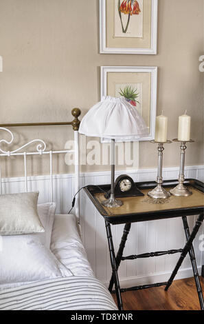 Tray table on side of white metal bed in bedroom    UK AND IRISH RIGHTS ONLY Stock Photo