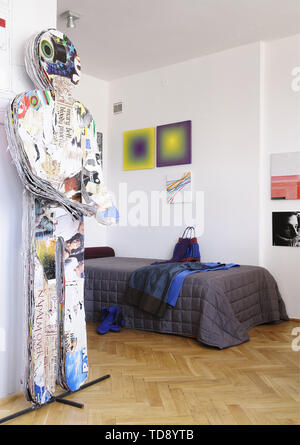 Figure of paper man next to bed with handbag and blue dress lying on it   UK & IRISH USE ONLY Stock Photo