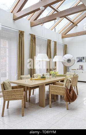 Dining room with dining table and wicker chairs in orangery    UK AND IRISH RIGHTS ONLY Stock Photo