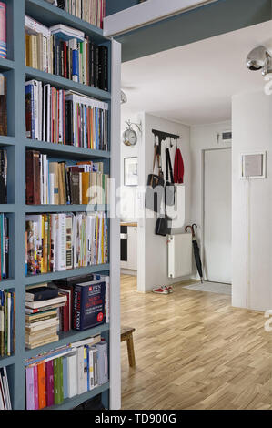 Bookcase in hallway next to apartment entrance with leather handbags on coat hanger   UK AND IRISH RIGHTS ONLY Stock Photo