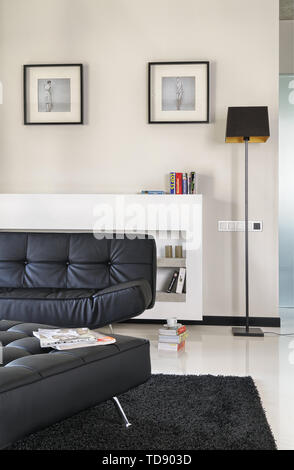 Leather Ottoman And Sofa In Front Of Concrete Shelves Built In Radiator Cover In Modern Living Room Uk And Irish Rights Only Stock Photo Alamy