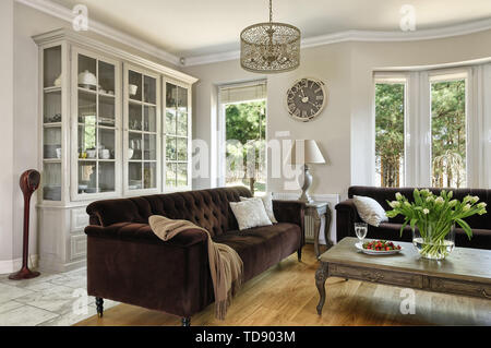Wooden coffee table in front of two tufted sofas in living room    UK AND IRISH RIGHTS ONLY Stock Photo
