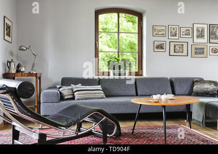 Tea items on top of coffee table in front of grey sofa in living room    UK AND IRISH RIGHTS ONLY Stock Photo