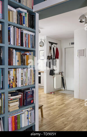 Bookcase in hallway next to apartment entrance with leather handbags on coat hanger   UK & IRISH USE ONLY Stock Photo