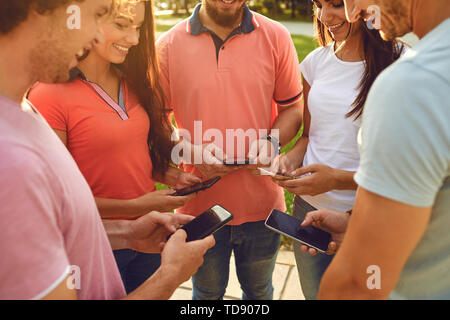 A group of young people raised their hands up with mobile phones. Concept of using mobile phones. Stock Photo