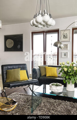 Black leather Barcelona Chair and sofa around transparent coffee table in modern sitting room   UK & IRISH USE ONLY Stock Photo