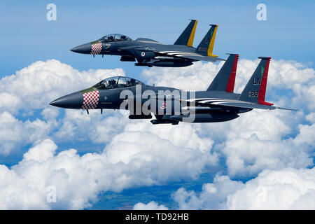 A pair of heritage painted F-15E Strike Eagles assigned to the 48th Fighter Wing conduct aerial maneuvers over southern England June 9, 2019. The Liberty Wing conducts routine training daily to ensure the 48th Fighter Wing brings unique air combat capabilities to the fight when called upon by United States Air Forces in Europe-Air Forces Africa. (U.S. Air Force photo/ Tech. Sgt. Matthew Plew) Stock Photo