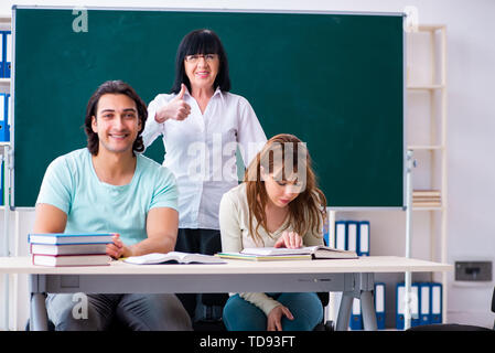 Old teacher and students in the classroom Stock Photo