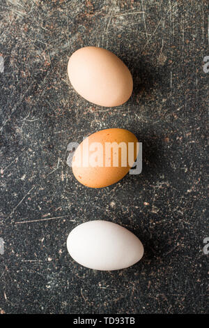 Raw chicken eggs on old kitchen table. Top view. Stock Photo