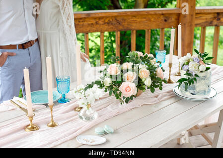 Wedding decoration table in the garden, floral arrangement, candles In the style vintage on outdoor. Wedding cake with flowers. Decorated table with f Stock Photo