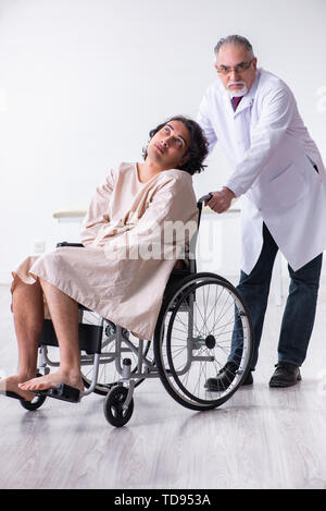 The old male doctor psychiatrist and patient in wheel-chair Stock Photo