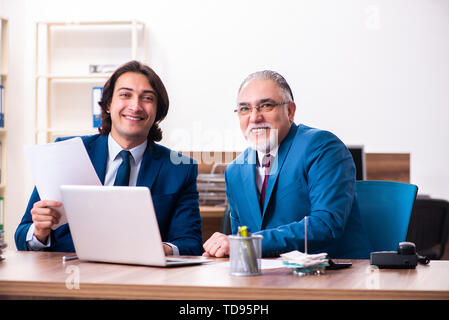 Young and old employees working together in the office Stock Photo