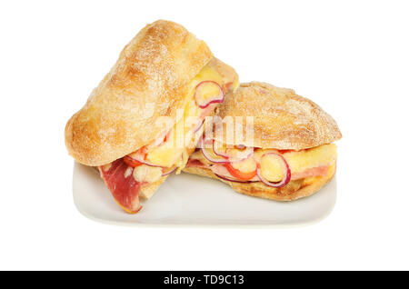 Toasted cheese, ham, tomato and red onion in ciabatta rolls on a plate isolated against white Stock Photo