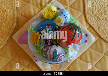 A bowl filled with colorful Easter decorations from above Stock Photo
