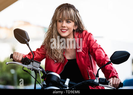 Beautiful young woman ridint on motorcycle Stock Photo