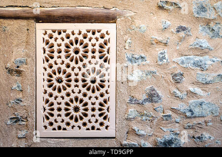Old & Traditional Handicraft pattern window on a stone wall. From Muttrah Fort, Muscat, Oman. Stock Photo