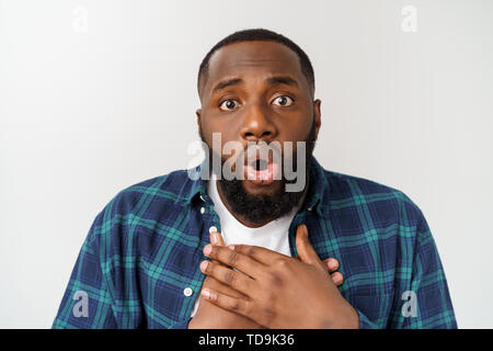 surprised young dark-skinned African American man student staring at camera with shocked look. Stock Photo