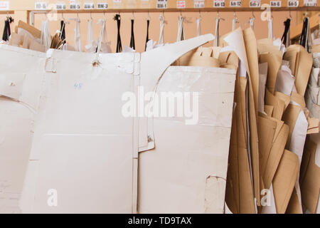 Patterns for sewing hang on the wall. many embroidery crown. industrial production of clothing, a large number of paper sewing designs Stock Photo