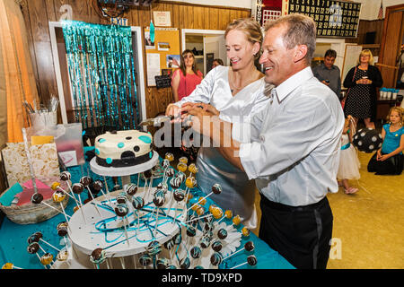 Bride & groom cut the cake at wedding reception;  Congressional Church; Buena Vista; Colorado; USA Stock Photo