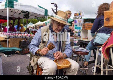 male carving a wooden bowl in a market Stock Photo
