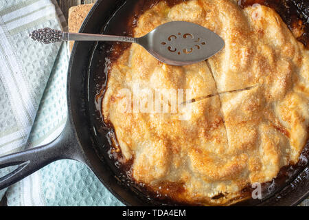 Apple pie baked in a cast iron skillet with a butter caramel sauce and golden crust Stock Photo