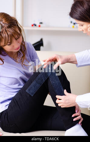 Female doctor checking patient's joint flexibility with goniometer Stock Photo