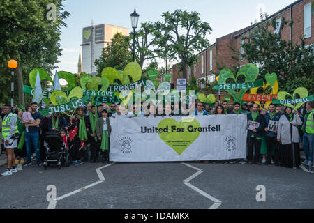 London, UK. 14th June 2019. The walk in silence from close to Grenfell Tower remembering the victims of the disaster on the second anniversary of the disastrous fire which killed 72 and left survivors traumatised halts briefly with the tower behind them. Promises made by Theresa May and Kensington & Chelsea council have not been kept and the enquiry seems to be simply providing an excuse for inaction. Credit: Peter Marshall/Alamy Live News Stock Photo