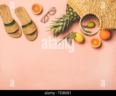Summer apparel items and fresh fruits over pastel pink background Stock Photo