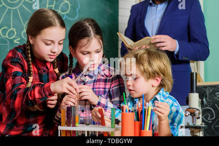 Inspired to work hard. happy children teacher. doing experiments with liquids in chemistry lab. chemistry lab. back to school. kids in lab coat learning chemistry in school laboratory. Stock Photo