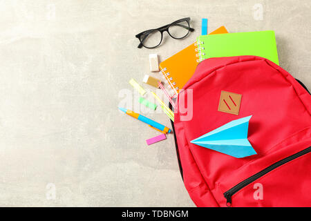 Flat lay composition with backpack and school supplies on grey background Stock Photo