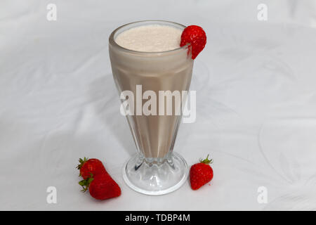 Strawberry Milkshake in tall Glass with Strawberry on edge Stock Photo