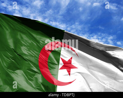 waving flag of Algeria close up against blue sky Stock Photo