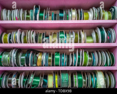 Green and yellow ribbon spools on display in shop Stock Photo