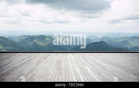Empty brick floor with green hills Stock Photo