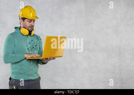 modern building supervisor keeps the computer in his hands, technology at work Stock Photo