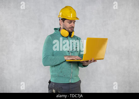 modern building supervisor keeps the computer in his hands, technology at work Stock Photo