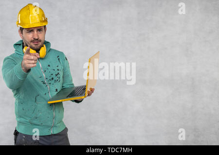 modern building supervisor keeps the computer in his hands, technology at work Stock Photo