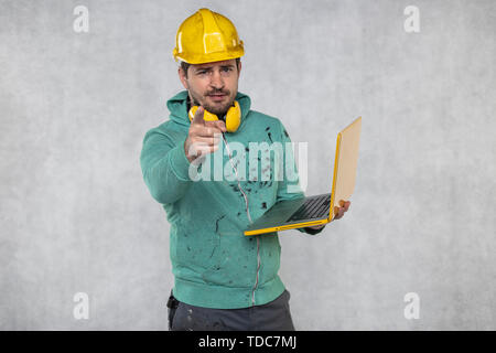modern building supervisor keeps the computer in his hands, technology at work Stock Photo