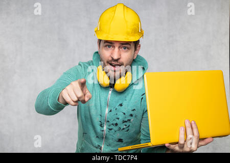 modern building supervisor keeps the computer in his hands, technology at work Stock Photo