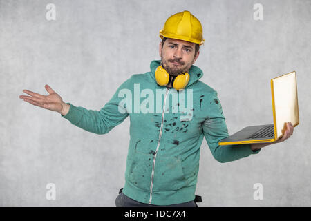 modern building supervisor keeps the computer in his hands, technology at work Stock Photo