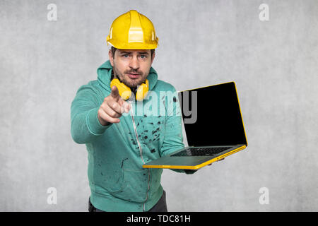 modern building supervisor keeps the computer in his hands, technology at work Stock Photo