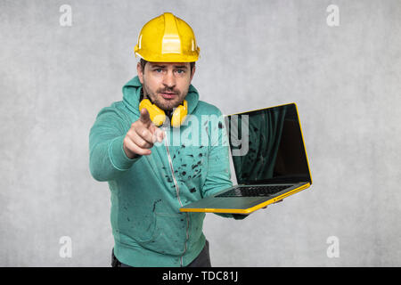 modern building supervisor keeps the computer in his hands, technology at work Stock Photo