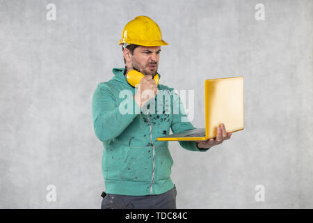 modern building supervisor keeps the computer in his hands, technology at work Stock Photo