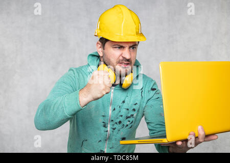 modern building supervisor keeps the computer in his hands, technology at work Stock Photo